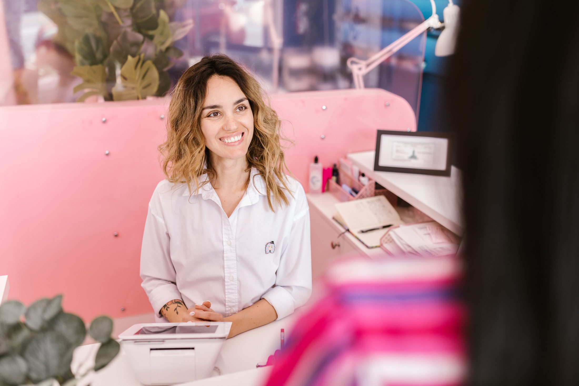 A Female Front Desk Receptionist Smiling A female front desk receptionist smiling to a client on UCSTAK's Contact page.