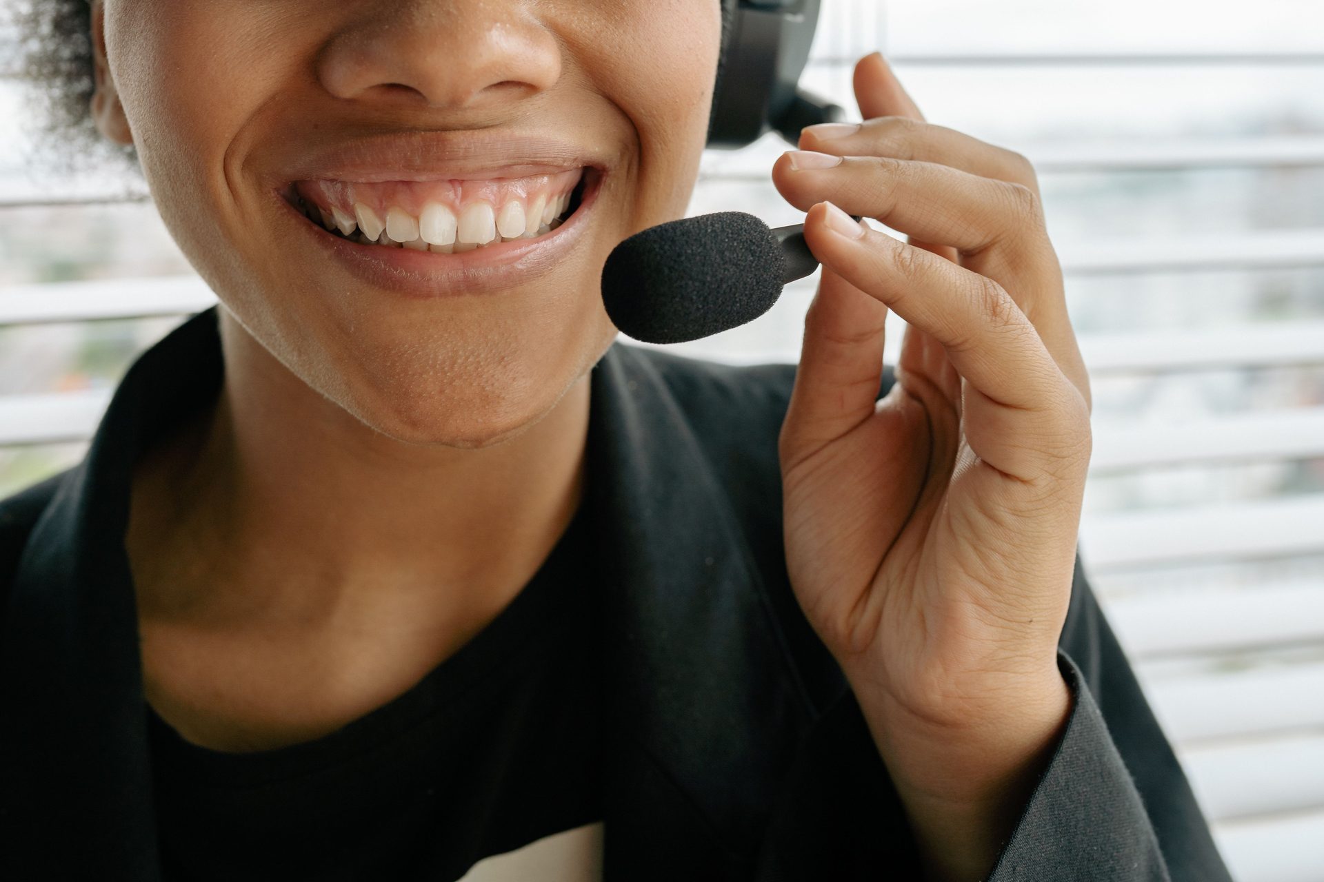 Close Up Photo of a Smiling Close up photo of a smiling woman holding microphone, representing UCSTAK's Headset Integration feature.