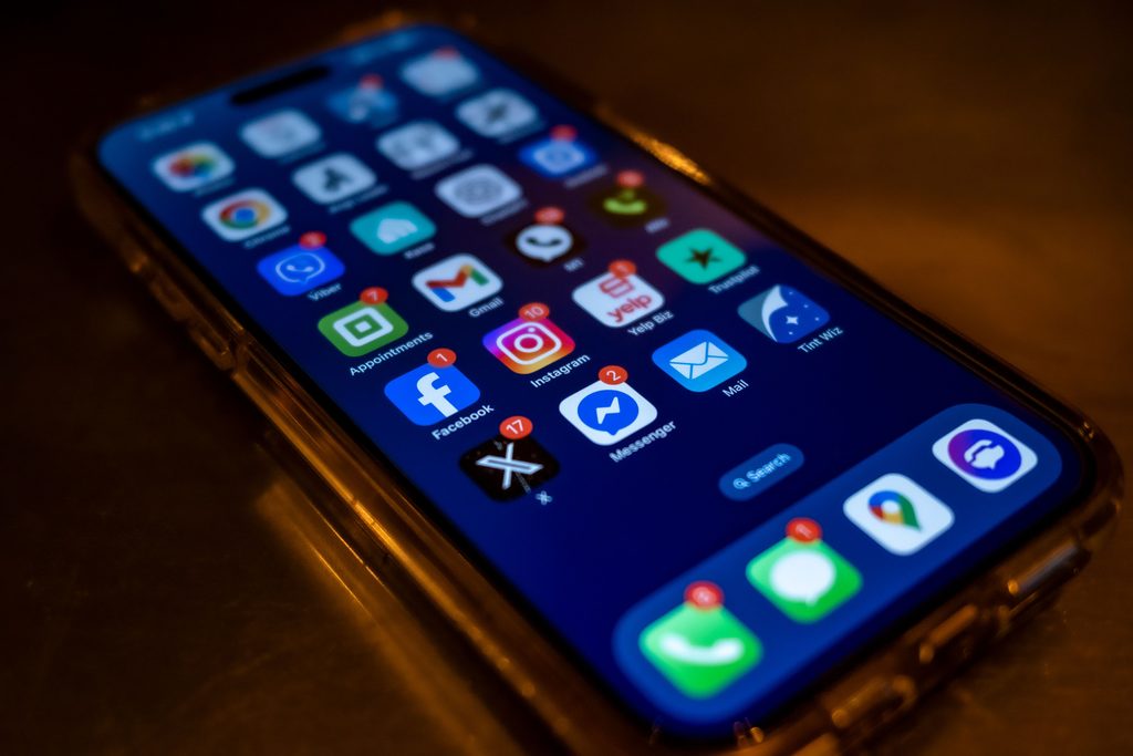 Close Up of Smartphone with Social Close up of smartphone with social media icons, representing UCSTAK's Facebook Messenger Integration feature.
