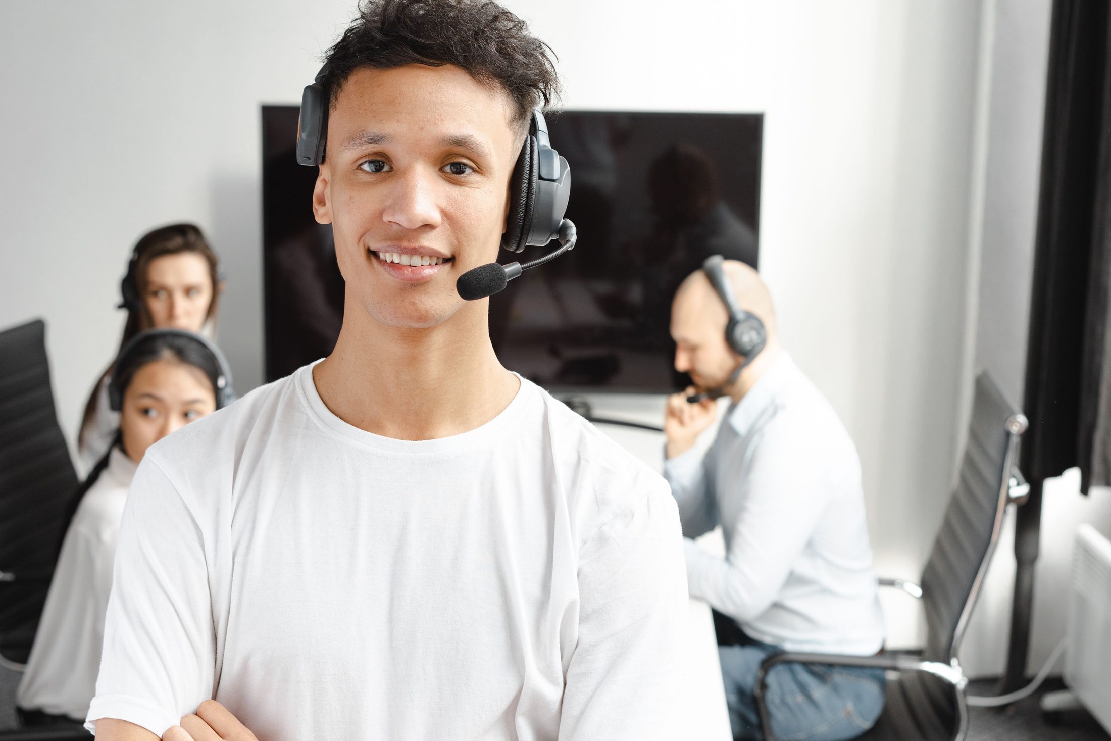 Man in a white shirt wearing a headset, representing UCSTAK's Progressive Dialer feature.
