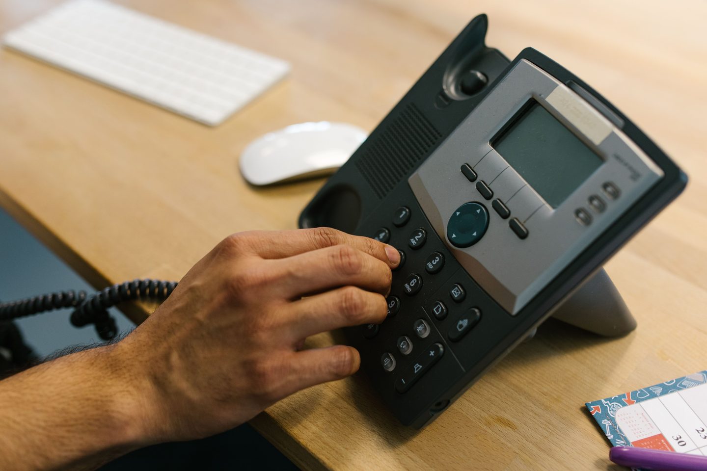 Person dialing the telephone, representing UCSTAK's Call Recording feature.
