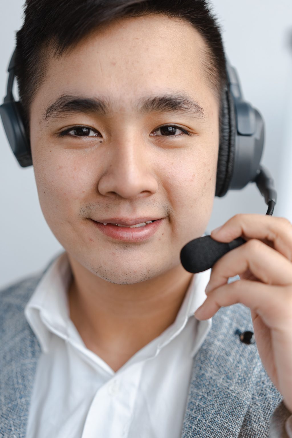 Man Smiling and Holding Microphone of Man smiling and holding microphone of the headset, representing UCSTAK's Recording Playback & Scrubbing feature.