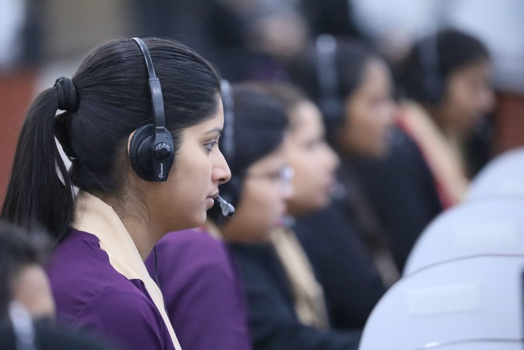 A Woman in Purple Shirt Wearing A woman in purple shirt wearing black headset, representing UCSTAK's Skills-Based Queue Routing feature.