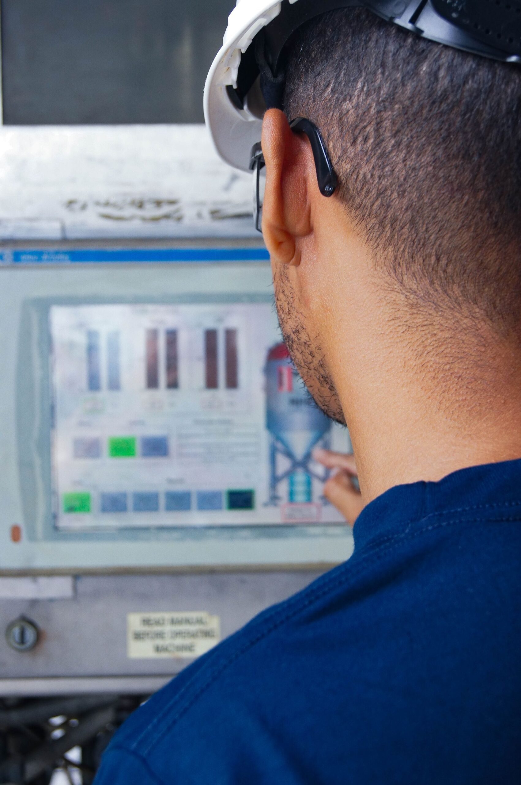 Engineer Operating Industrial Control Panel Engineer operating industrial control panel, representing UCSTAK's SLA Threshold Alerts feature.