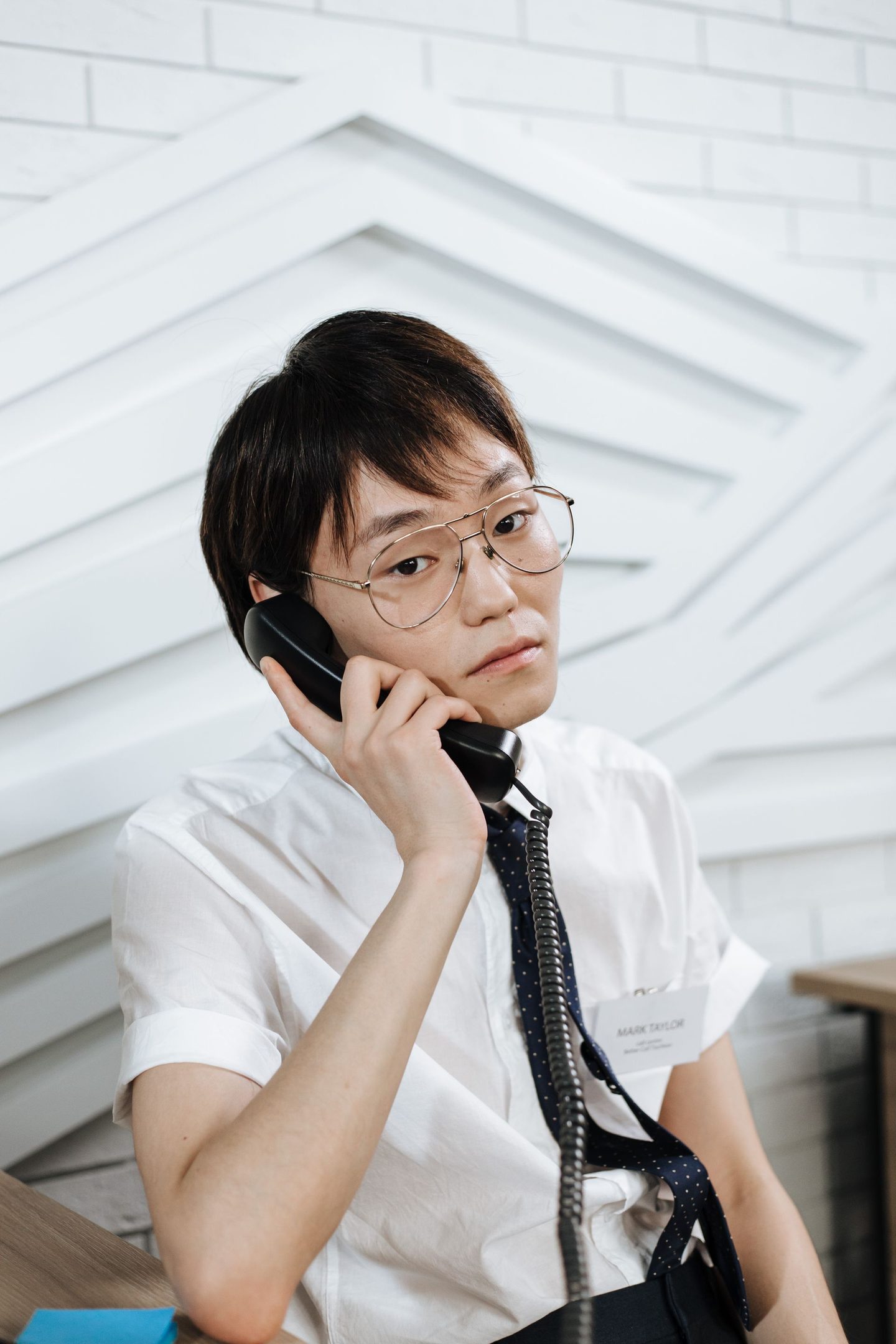 Portrait of a Man Holding a Portrait of a man holding a black telephone, representing UCSTAK's Auto Attendant (IVR) feature.