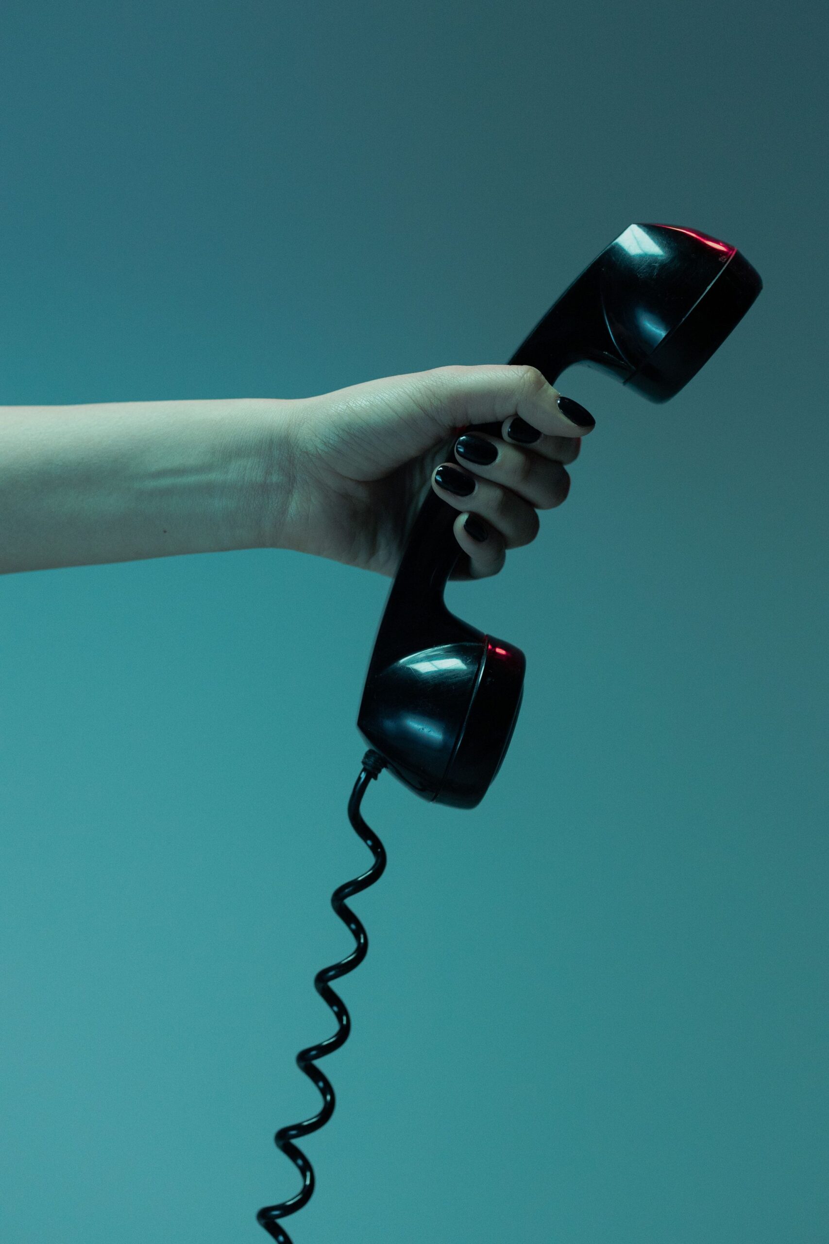 Close Up Shot of Person Holding Close up shot of person holding a black telephone, representing UCSTAK's Bilingual & Multi-Language Prompts feature.