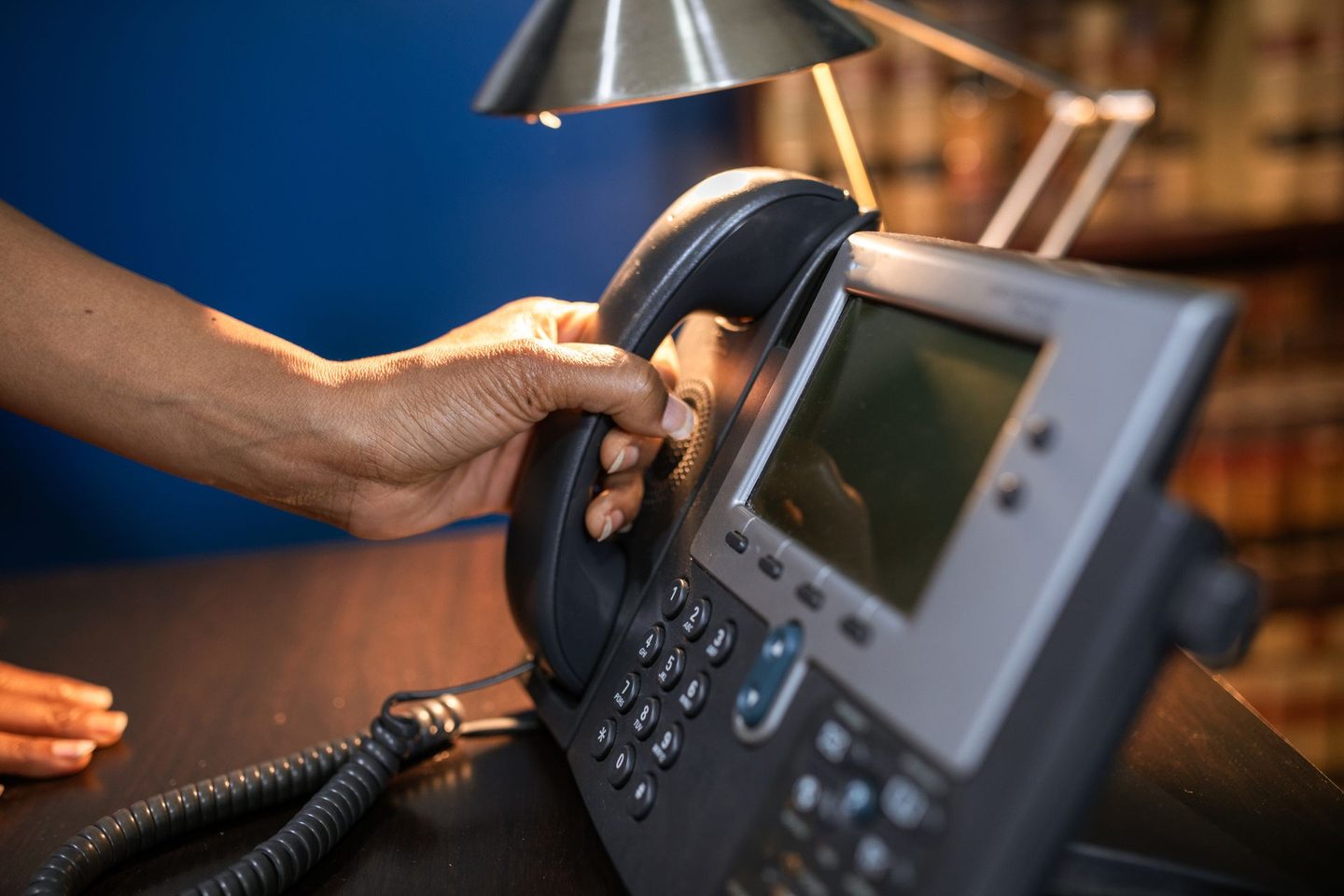 Person Holding a Telephone Person holding a telephone, representing UCSTAK's Department-Based Call Routing feature.