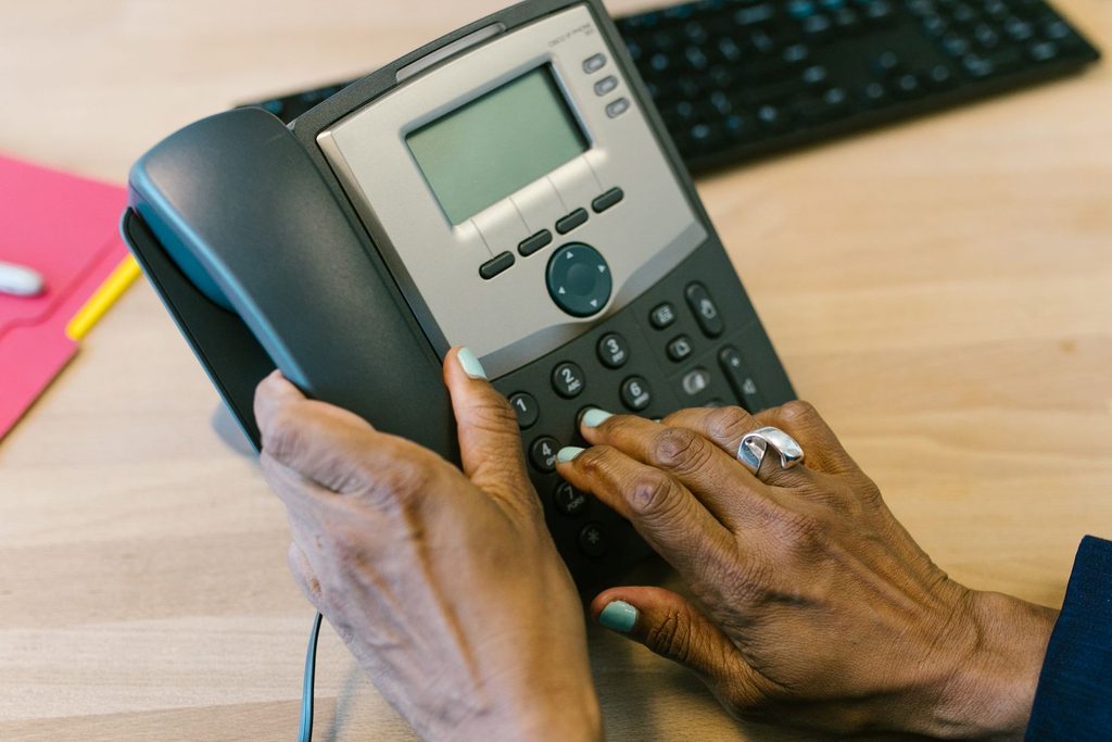 Person Holding a Telephone Person holding a telephone, representing UCSTAK's Dial-by-Extension feature.