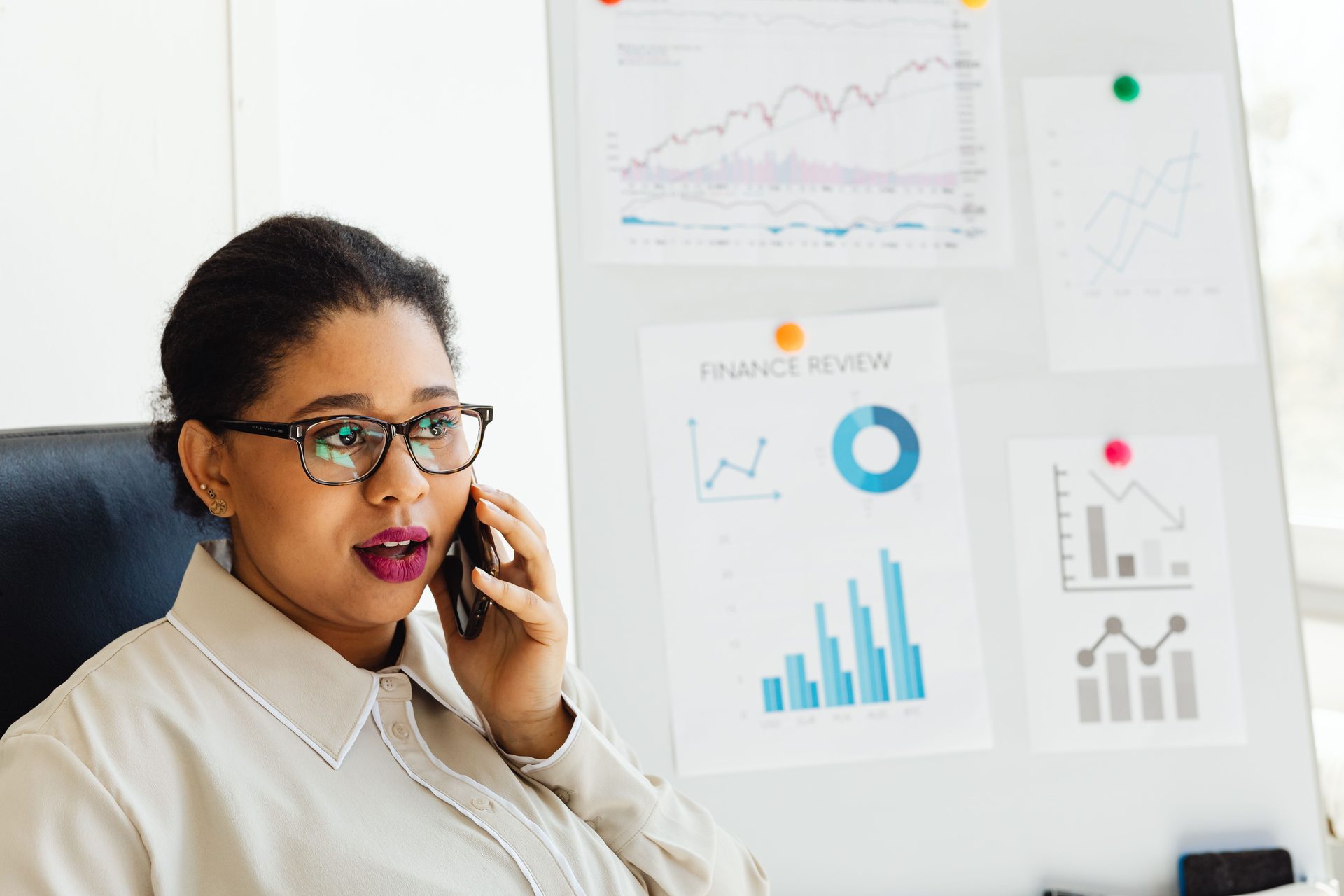 Woman wearing eyeglasses talking on the phone, representing UCSTAK's Call Tracking Numbers for Marketing feature.