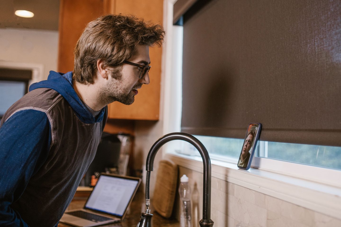 A Man Having a Video Call A man having a video call near the sink, representing UCSTAK's Remote Access & Work-From-Anywhere feature.