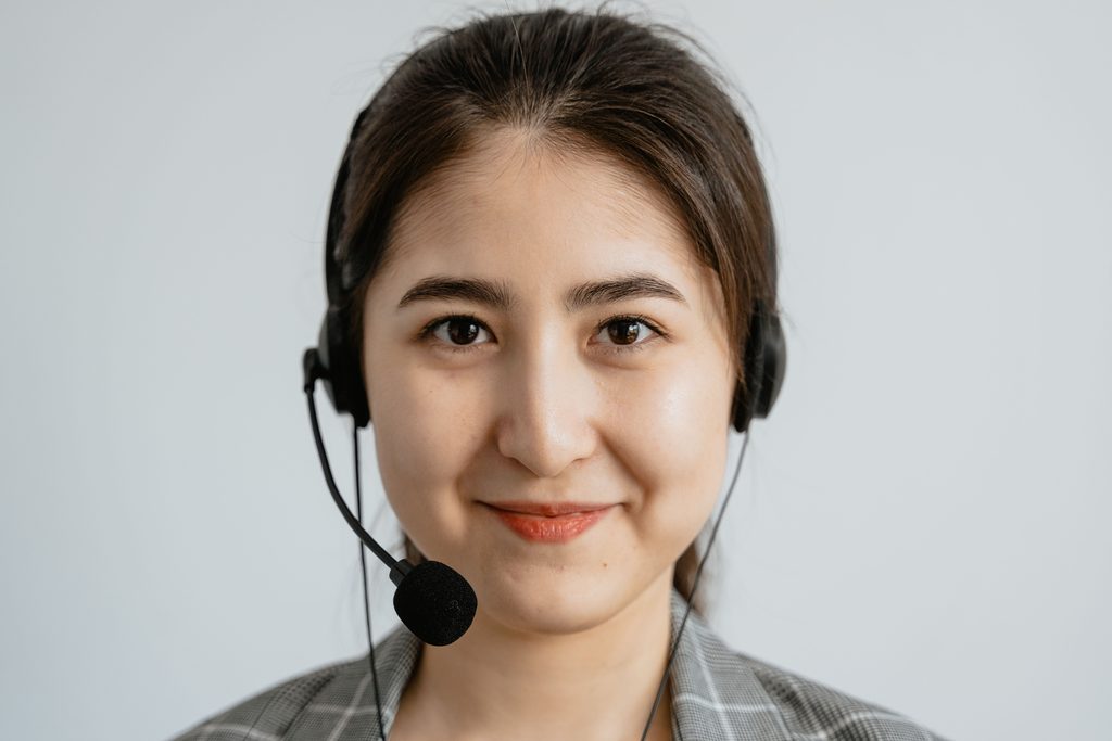 A Portrait of a Woman Wearing A portrait of a woman wearing a headset, representing UCSTAK's Routing by Skill Set feature.