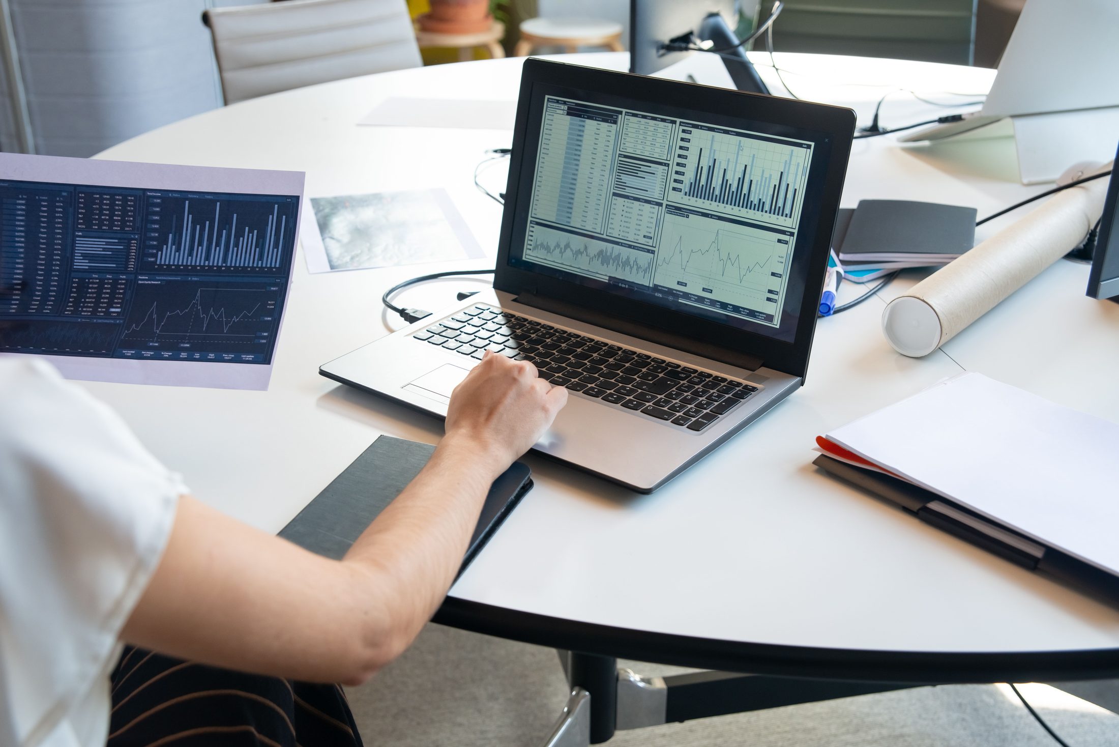 Photograph of a Paper and Laptop Photograph of a paper and laptop with graphs, representing UCSTAK's Visual Call Flow Designer feature.