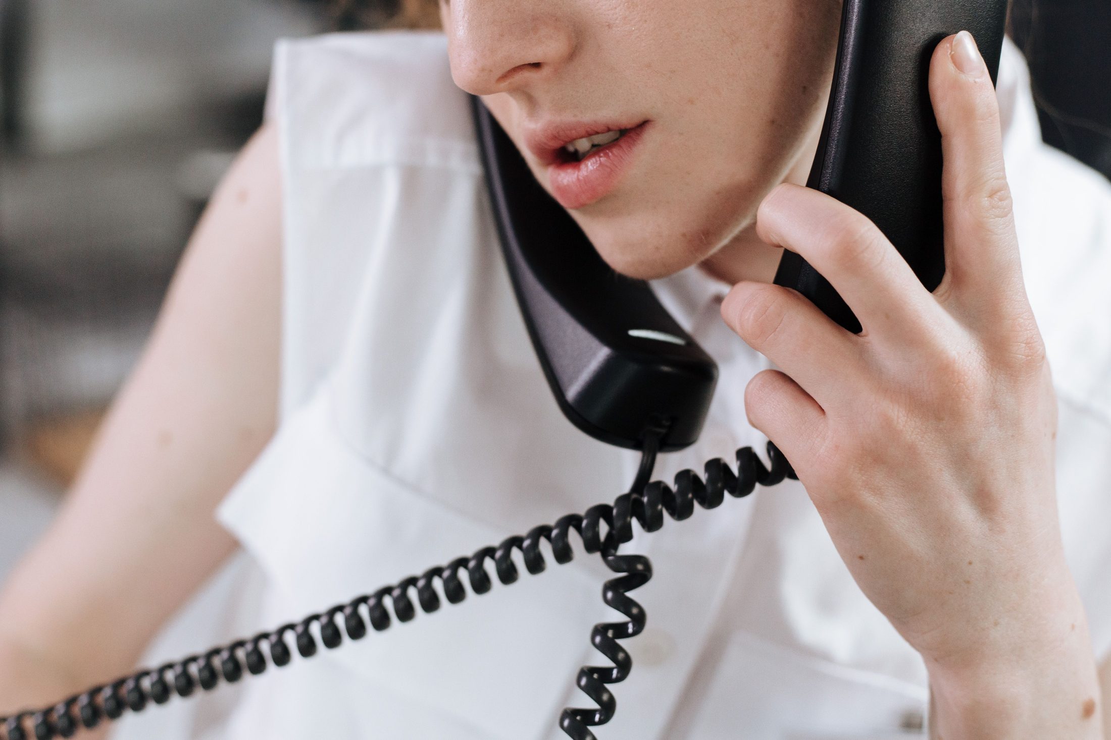 Woman talking on telephones, representing UCSTAK's Broadcast & Announcement Voicemail feature.