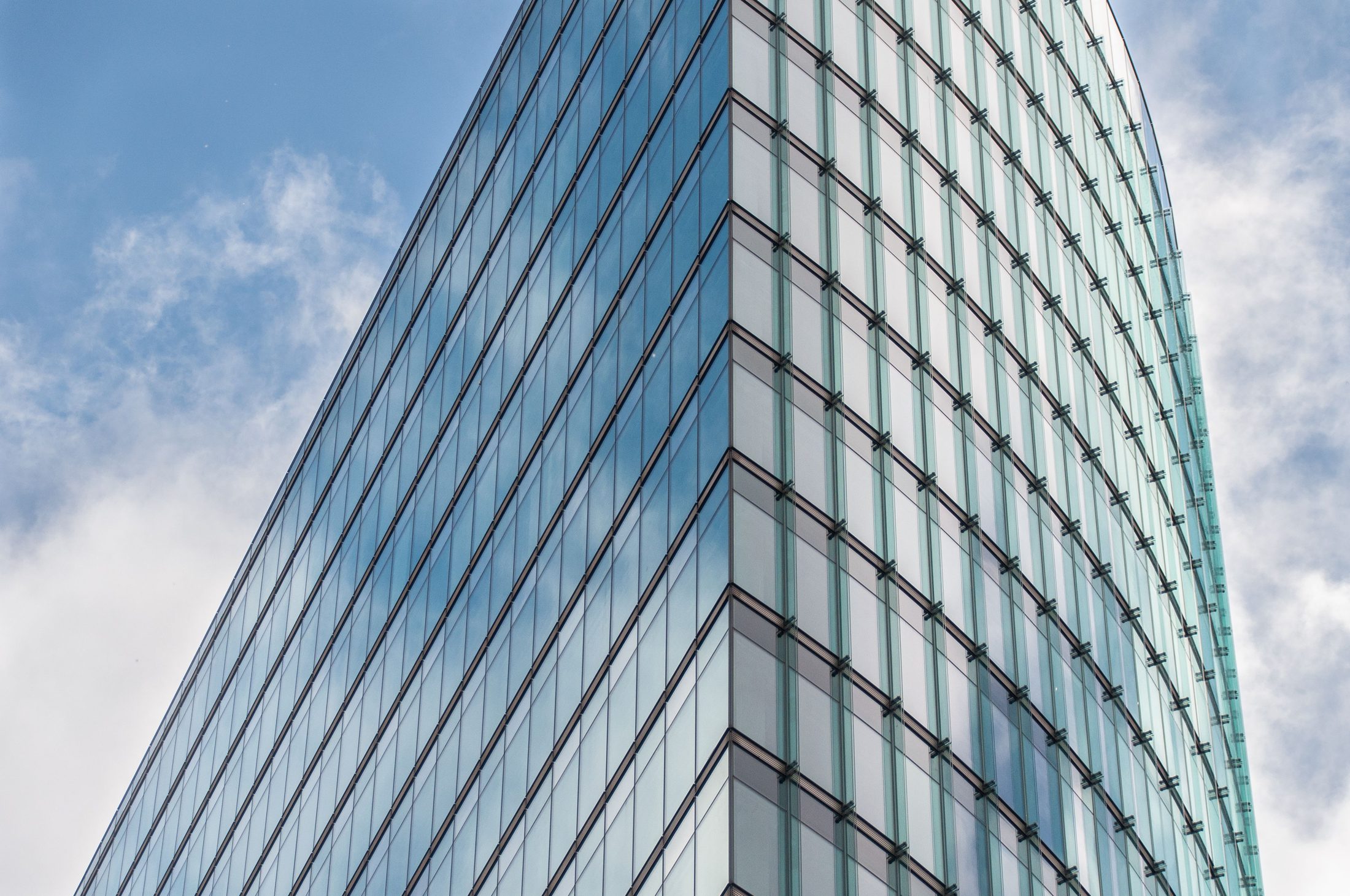 Modern glass skyscraper against blue sky on UCSTAK's News page.