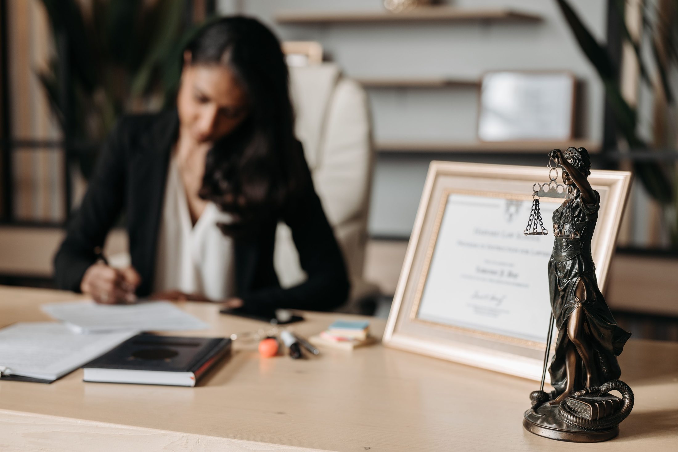 Lady Justice Figurine on Wooden Table Lady justice figurine on wooden table, representing UCSTAK's ISO 27001 Certification feature.