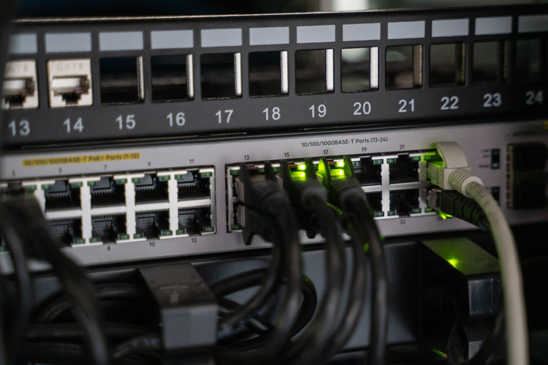 Close Up of a Bunch of Close up of a bunch of cables plugged into a device, representing UCSTAK's Router & Switch Configuration & Management feature.