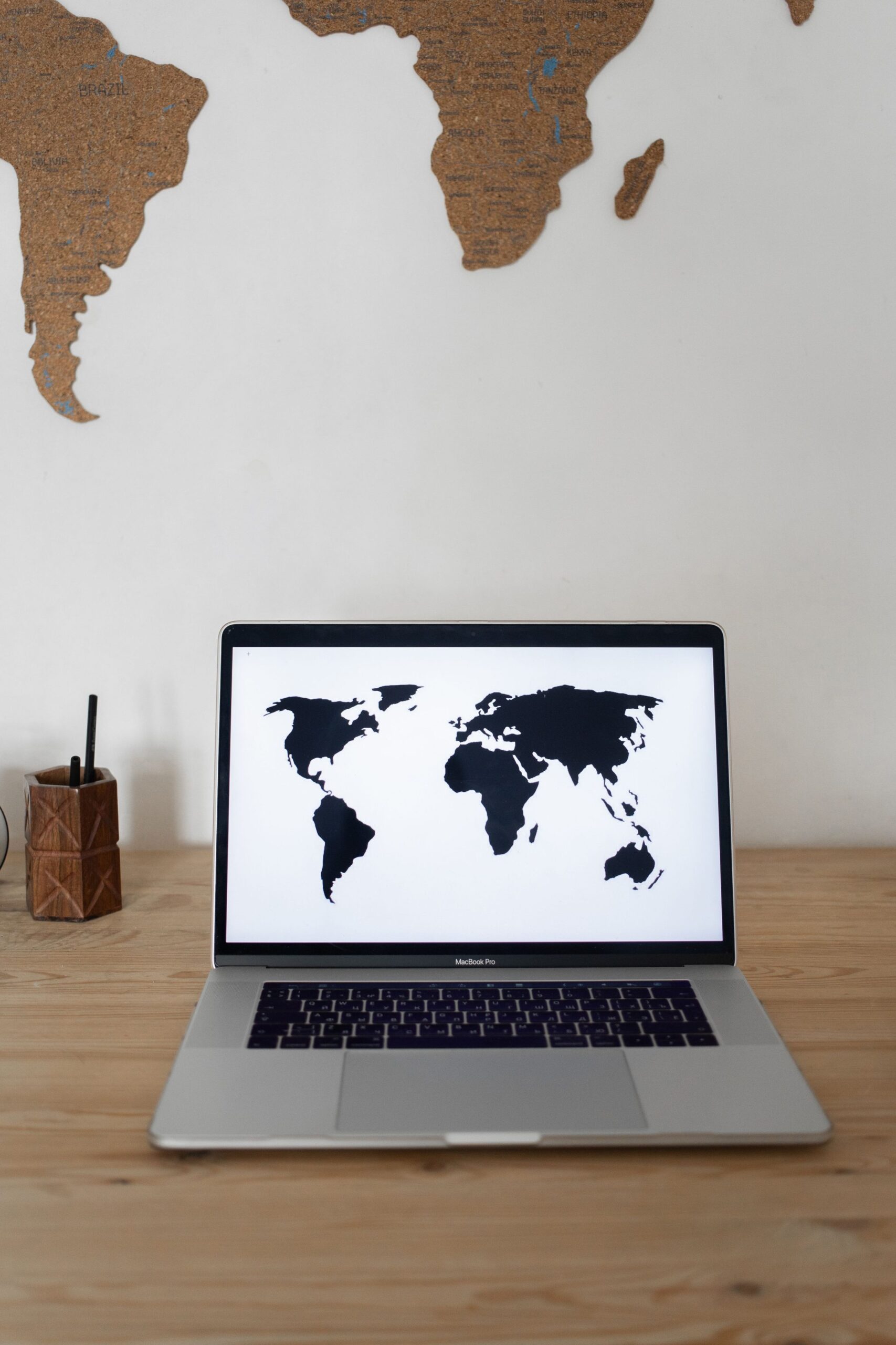 Laptop with world map on screen on table, representing UCSTAK's Country & Region Call Restrictions feature.