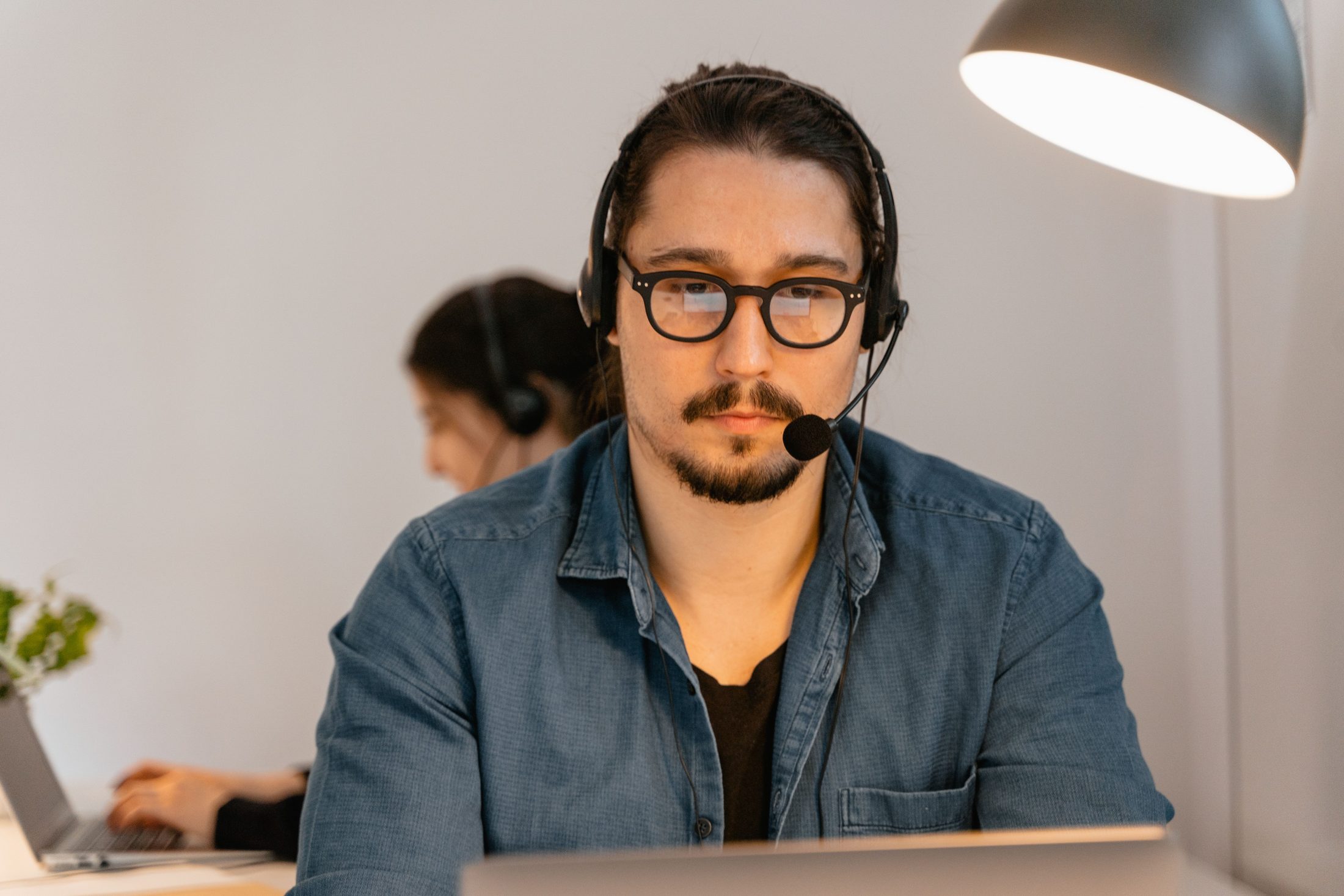 A Man Wearing a Headphones While A man wearing a headphones while working, representing UCSTAK's Call Center & Dispatch feature.