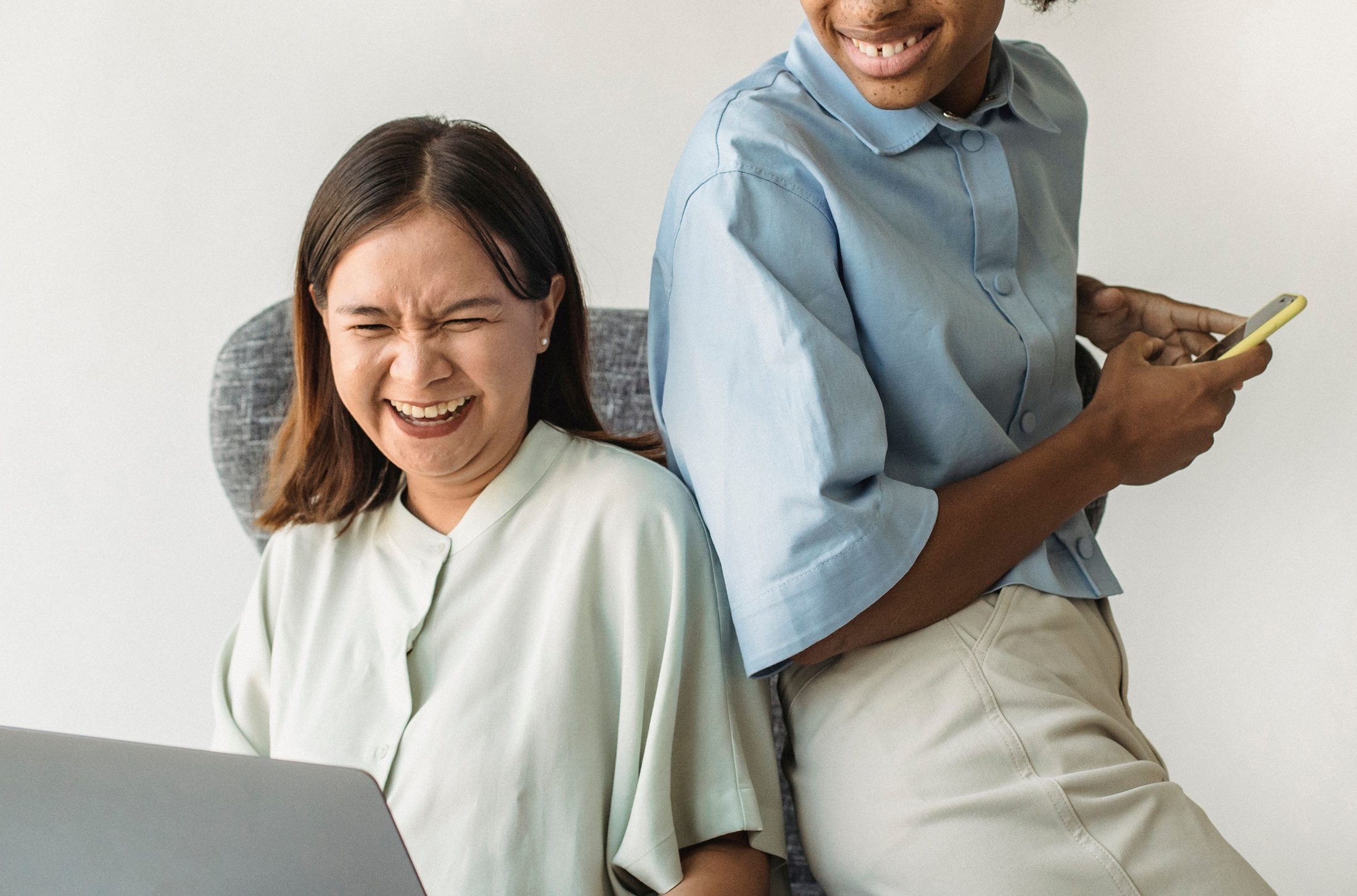 Two Women Laughing on an Armchair Two women laughing on an armchair on UCSTAK's Team page.