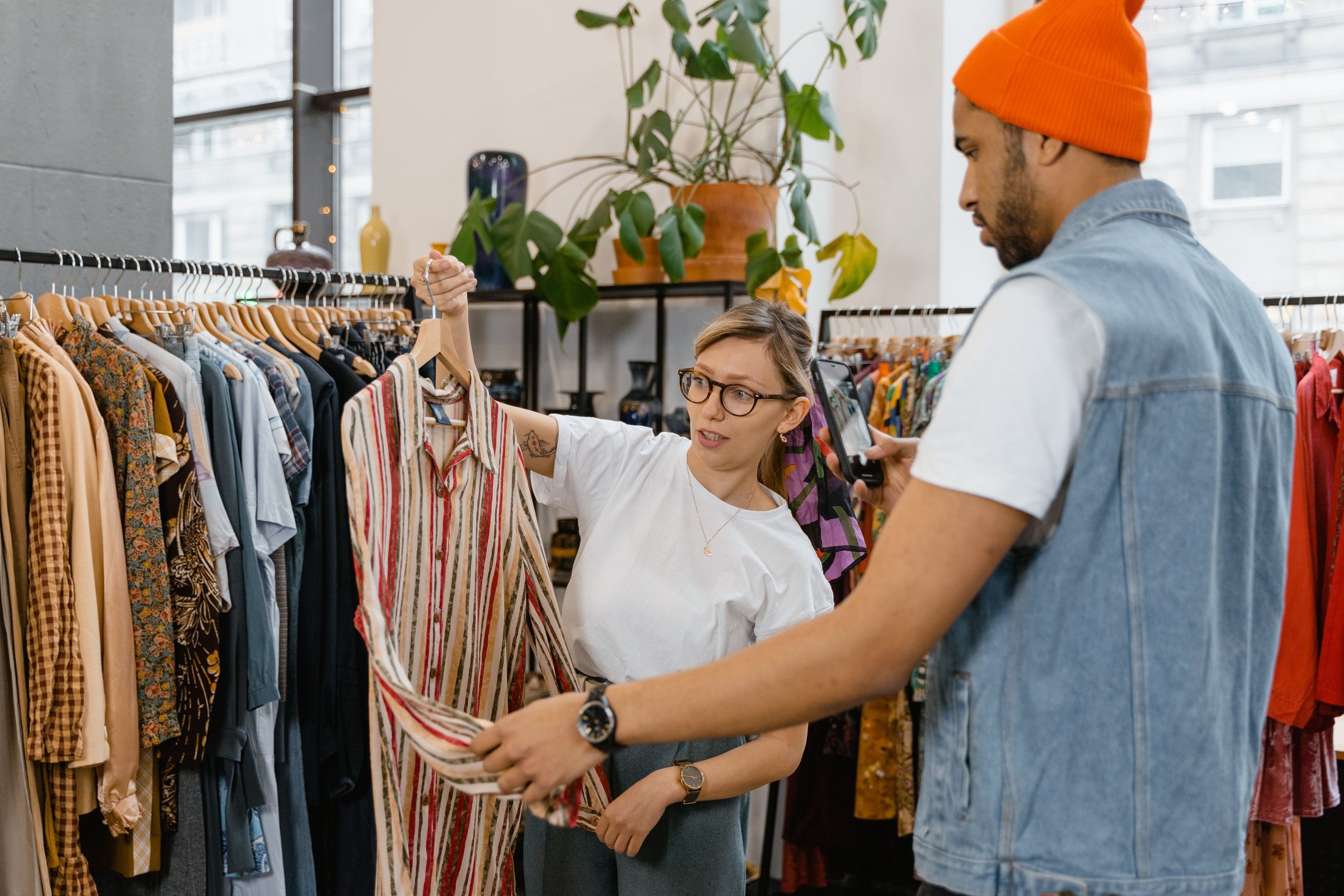 Woman holding clothing on a hanger on UCSTAK's Retail page.