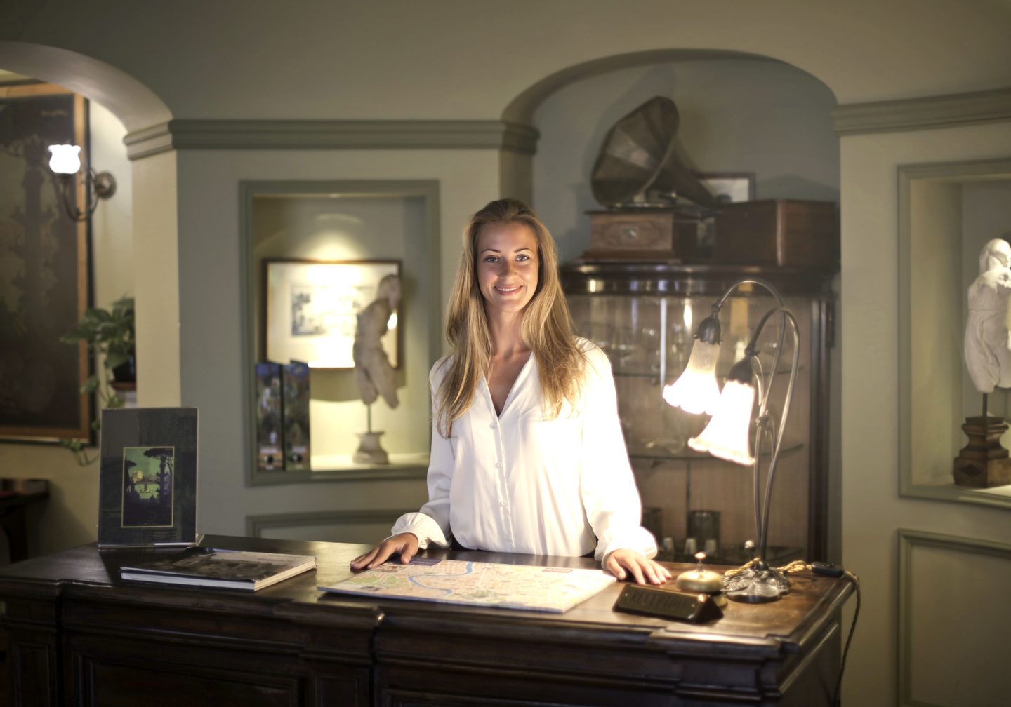 Hospitable woman standing behind front desk on UCSTAK's Hospitality page.