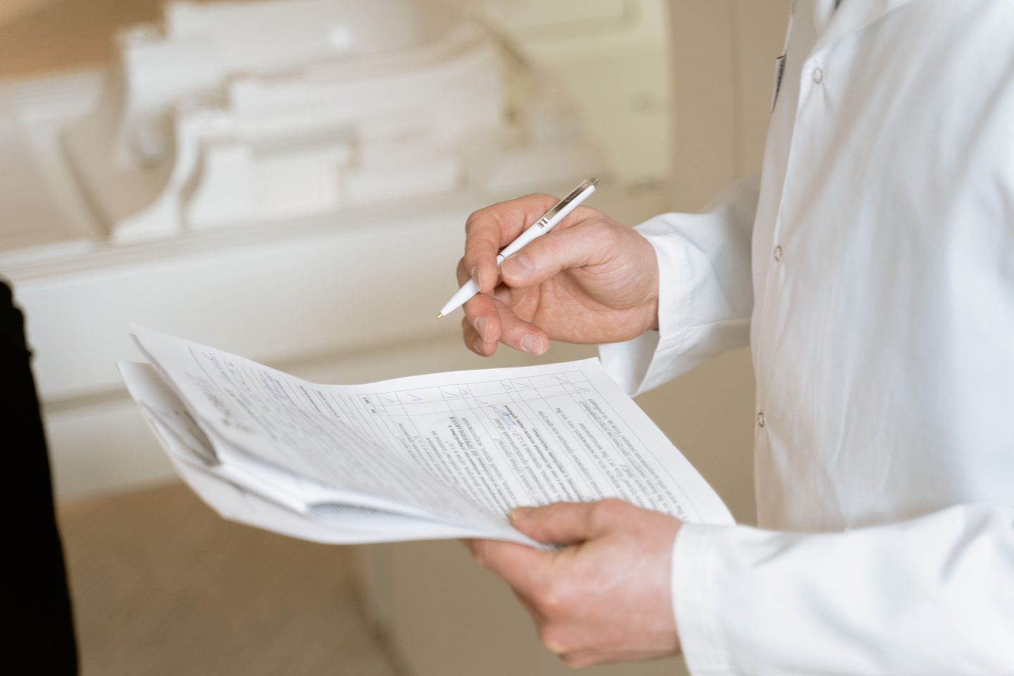 A person in white dress shirt holding a pen and paper on UCSTAK's Healthcare page.