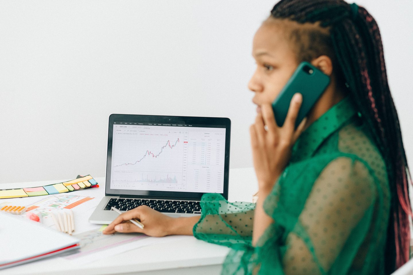 Woman in talking on the phone near a laptop on UCSTAK's Wealth Management page.