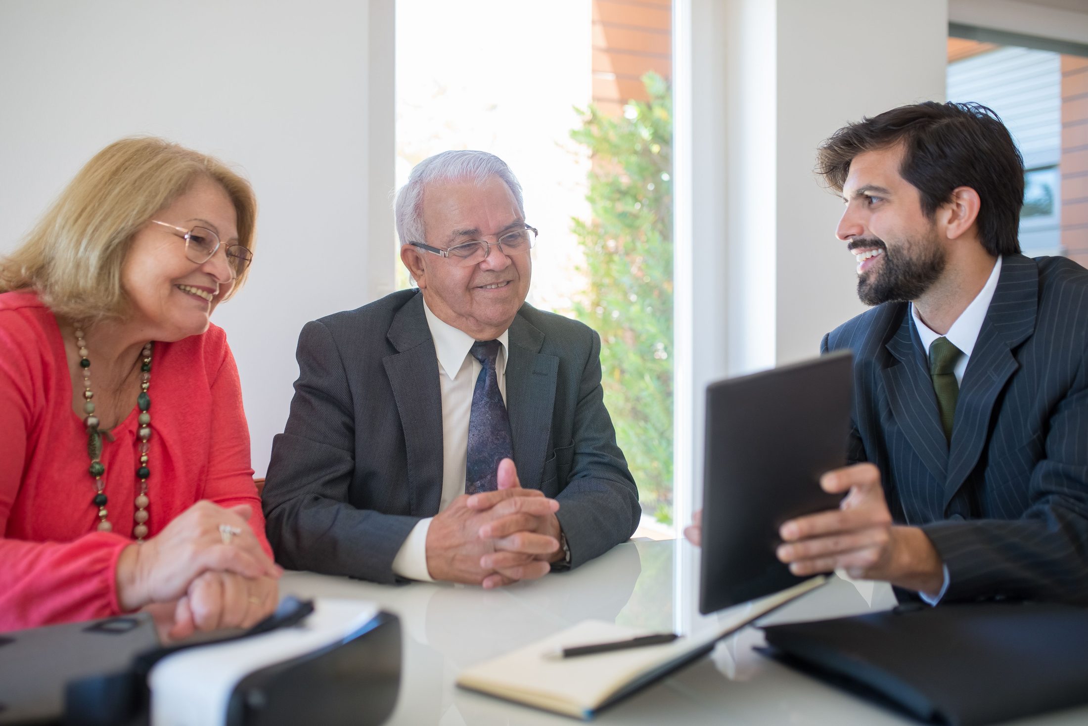 Man in black suit jacket sitting beside a man in gray suit on UCSTAK's Wealth Management page.