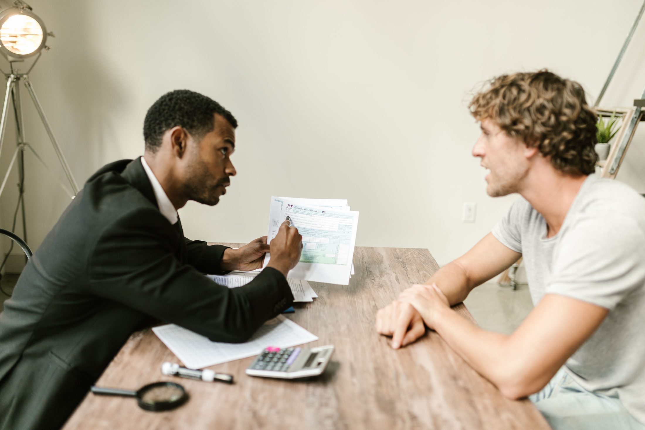 An agent showing documents to his client on UCSTAK's Accounting Firm page.