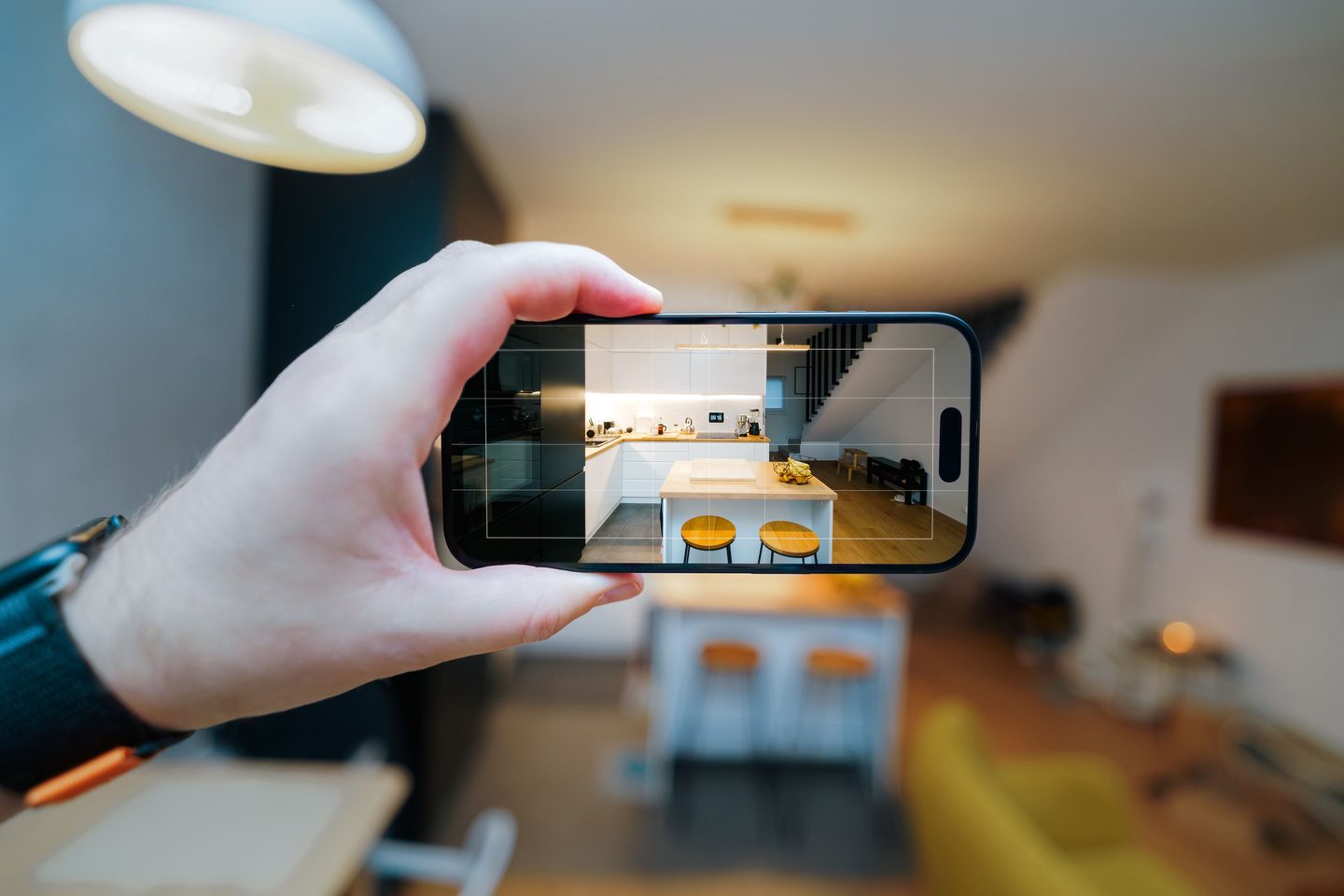 Smartphone capturing modern kitchen interior on UCSTAK's Realty Brokerage page.