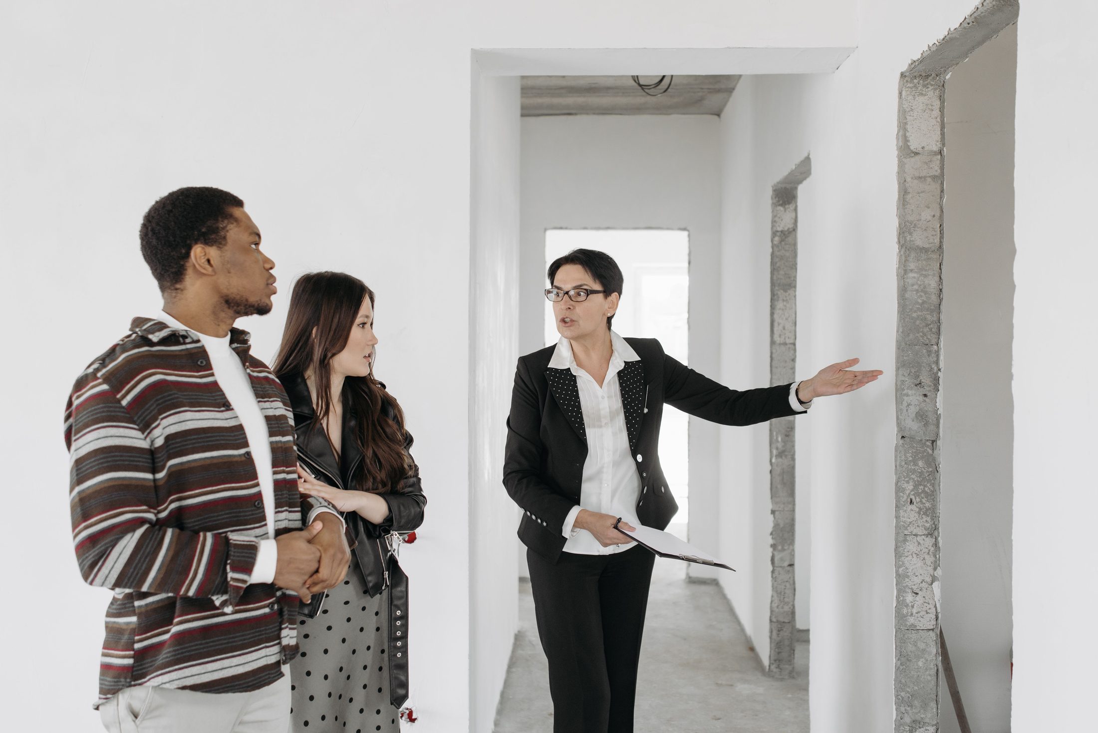 Real estate agent showing apartment to couple on UCSTAK's Realty Brokerage page.